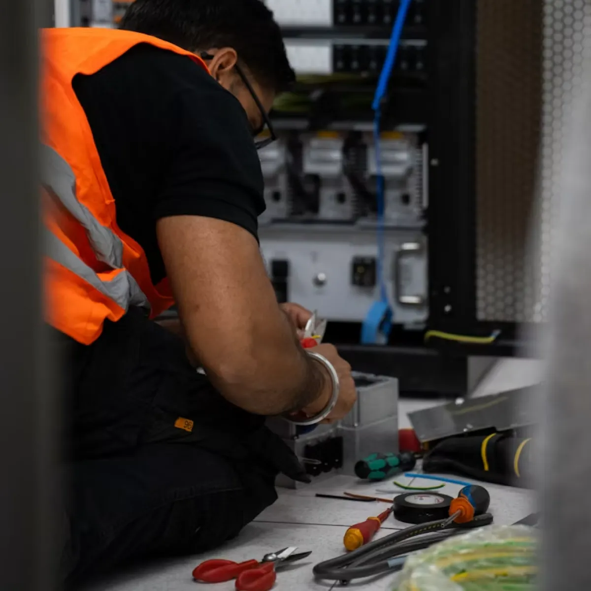 Técnico da EBM Redes instalando cabeamento estruturado em rack de rede